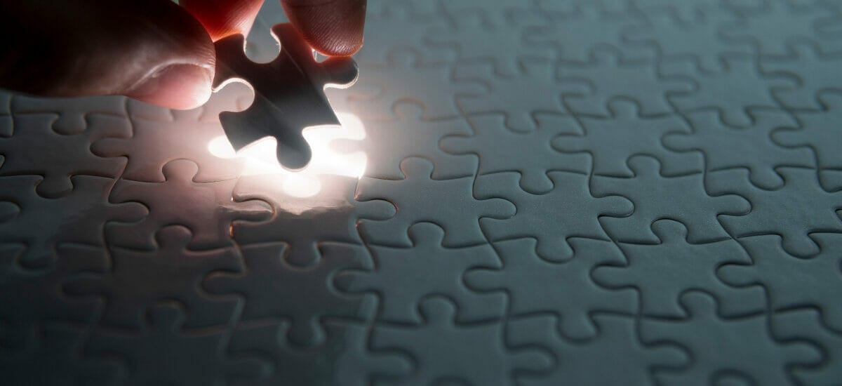 hand placing down the last piece of a puzzle