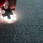 hand placing down the last piece of a puzzle
