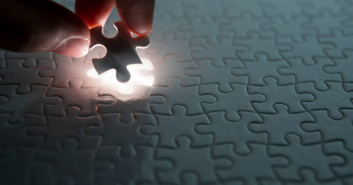hand placing down the last piece of a puzzle