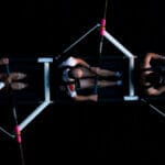 Collaborate: A crew team of four people rowing against a dark background