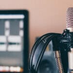 a podcast microphone and headset with a computer in the background