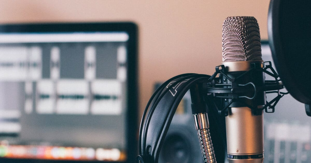 a podcast microphone and headset with a computer in the background