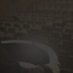 A podium with microphone on a stage with an empty audience; signaling leadership & how to communicate effectively.