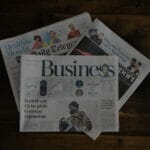 Three newspapers on a coffee table; signaling newsjacking.