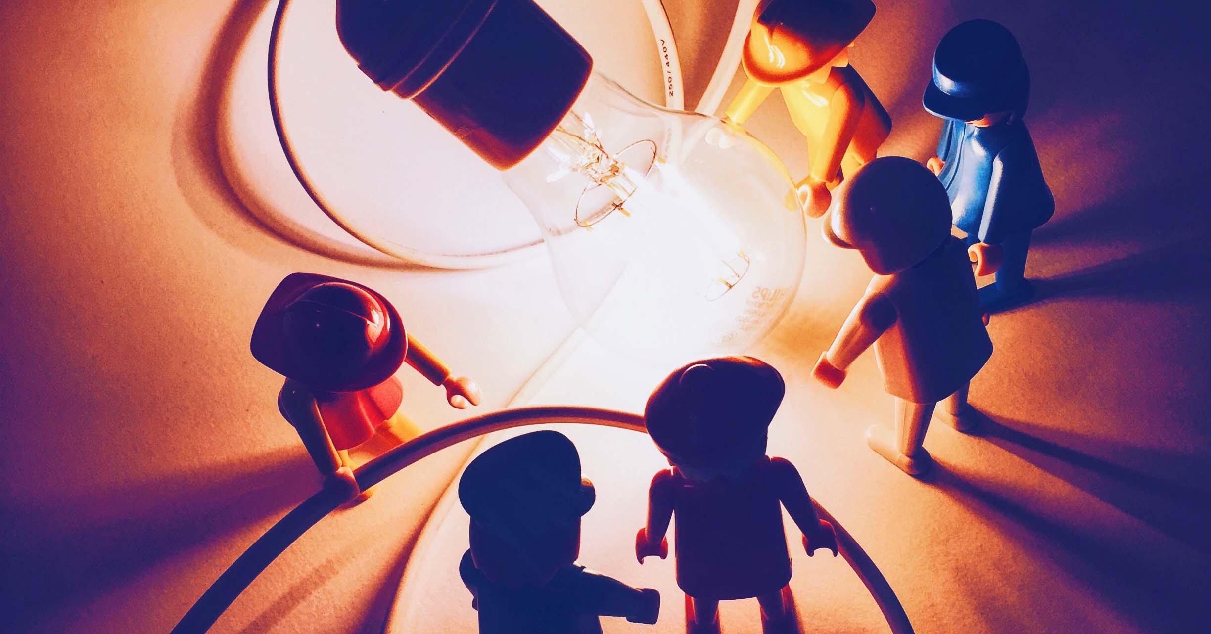 A team of Lego people being enlightened by a light bulb
