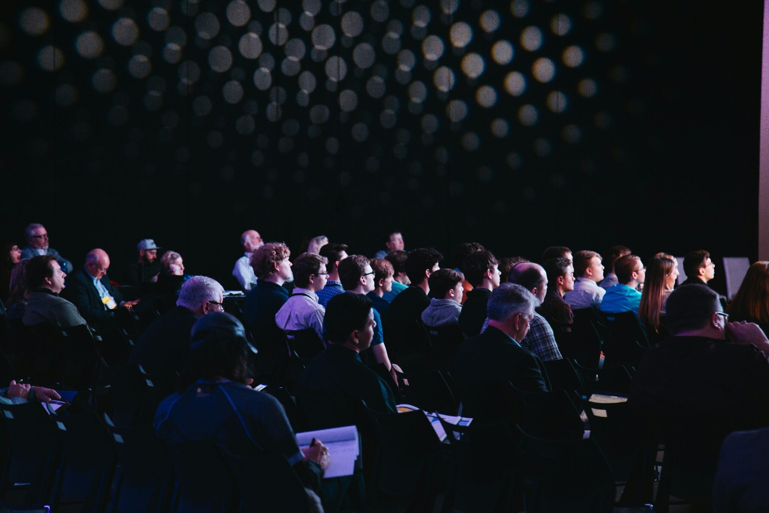 Conference attendees watching presentation in dark room